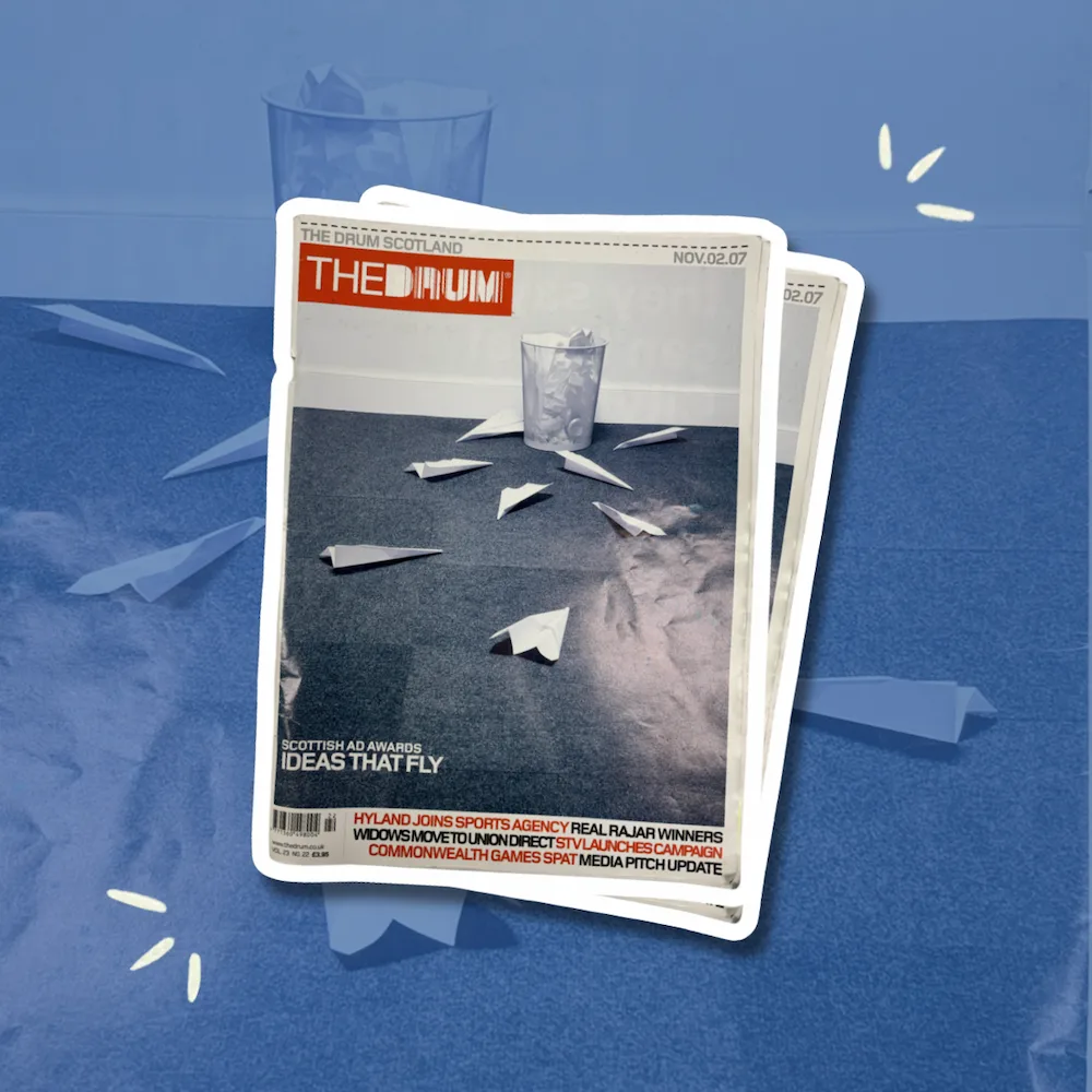 A vintage 2007 issue of The Drum Scotland rests over paper planes on a blue surface, recalling advertising’s earlier era.